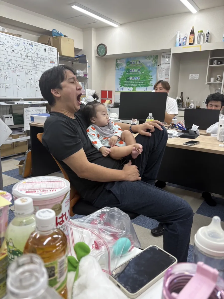 オフィスで赤ちゃんを抱く社員